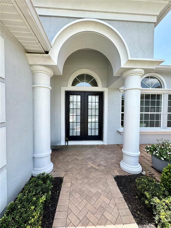 A front entryway features a brick walkway, two white columns, and a dark double door — 1539 ORMOND TERRACE, PARRISH, FL