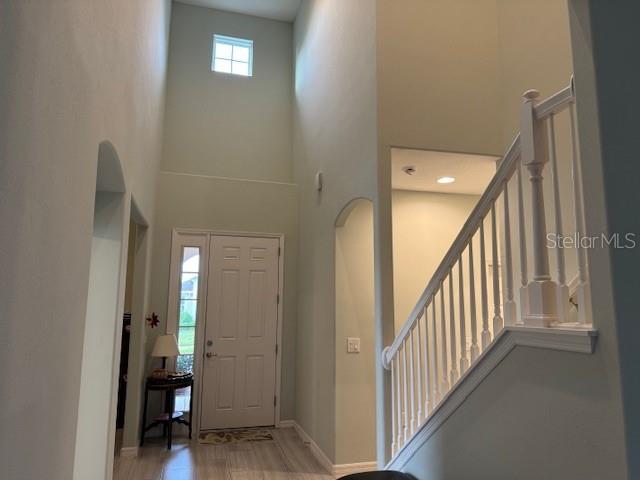 An entryway with a high ceiling, a white front door, and a staircase with white railings — 3200 WINGED FOOT ROAD, MOUNT DORA, FL