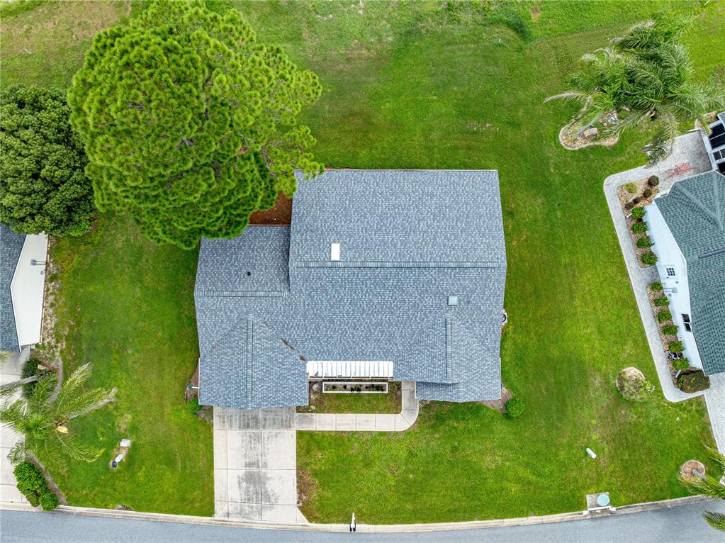 An aerial view shows a single-story house with a gray shingled roof and a driveway — 17873 SE 99TH AVENUE, SUMMERFIELD, FL