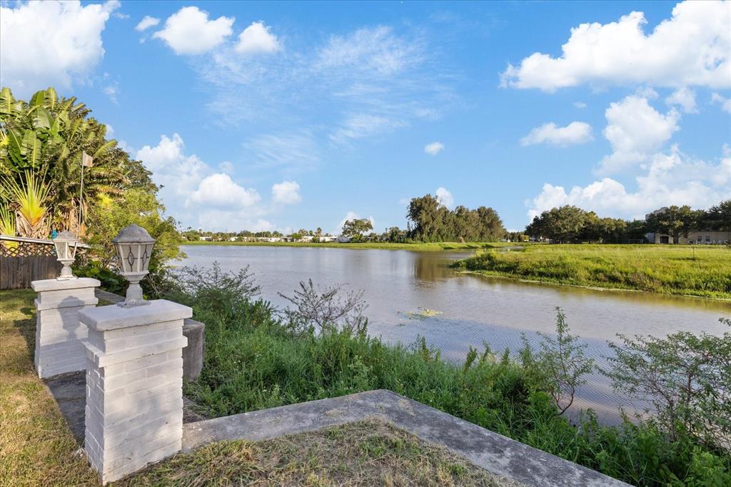 A view of a lake from a backyard with two white brick pillars and lamps — 2698 46TH AVENUE N, ST PETERSBURG, FL