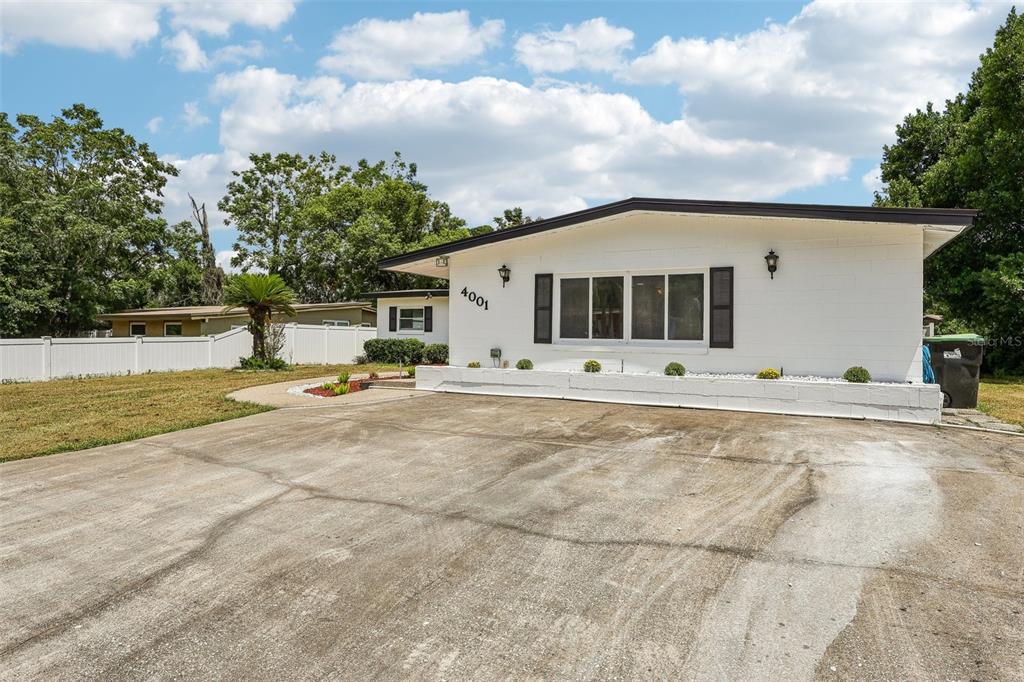 A white single-story house with a concrete driveway and a large front window — 4001 TIMBER TRL, ORLANDO, FL