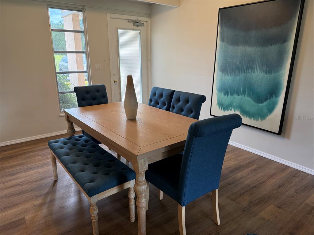 A galley kitchen features white cabinets, light countertops, stainless steel appliances, and wood-look flooring — 3421 CLUB CIRCLE, LAKESHORE, FL