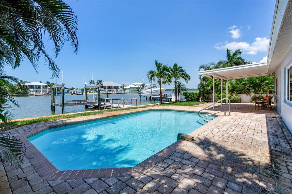 An aerial view shows three waterfront houses with docks and boats along a canal — 16458 REDINGTON DRIVE, REDINGTON BEACH, FL