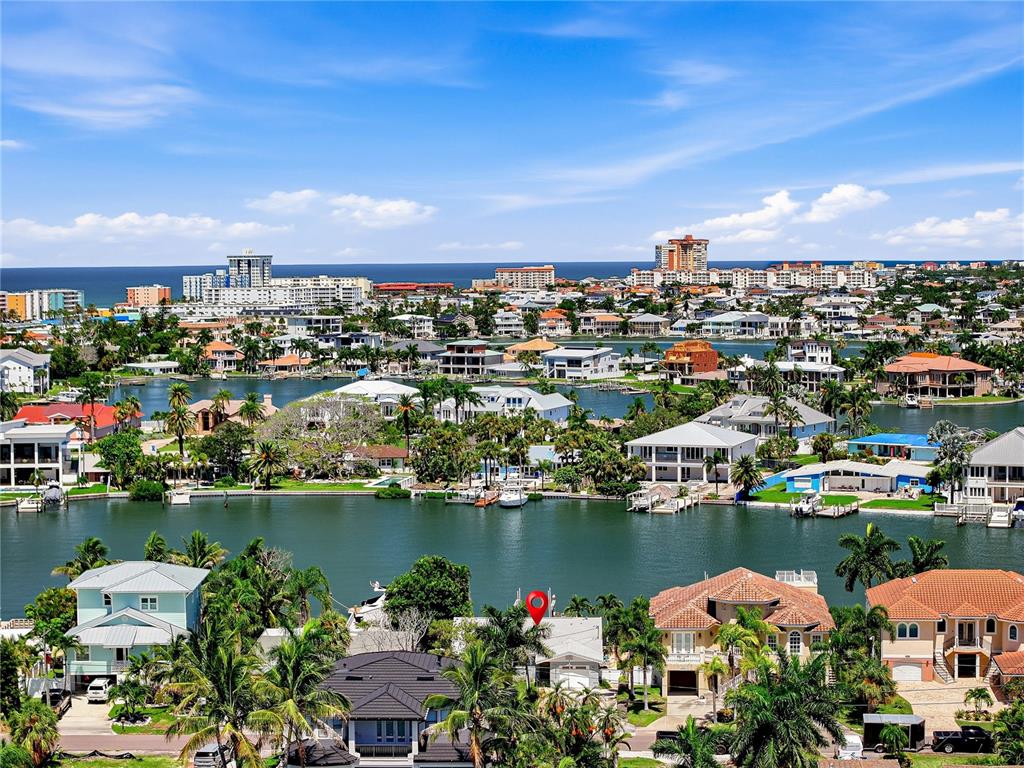 An aerial view shows waterfront homes with docks along a canal near the ocean — 16458 REDINGTON DRIVE, REDINGTON BEACH, FL