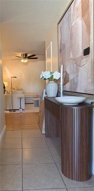 A tiled entryway features a curved wooden console table beneath a large abstract wall painting — 533 CASCADE CIRCLE UNIT 103, CASSELBERRY, FL