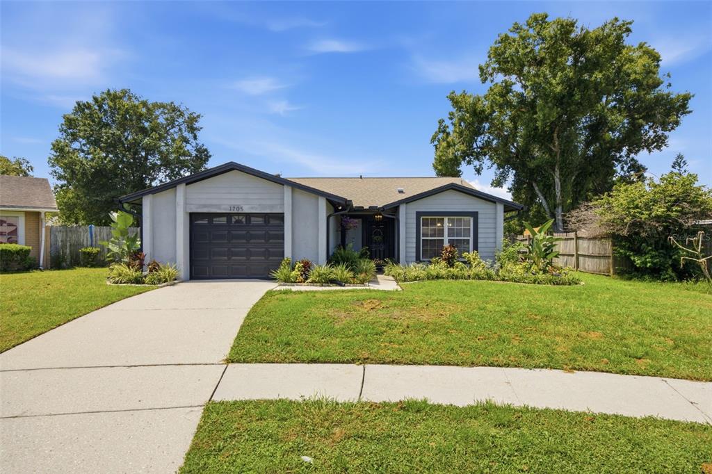 A single-story house with a gray exterior, a one-car garage, and a front lawn — 1705 CINNABAR COURT, BRANDON, FL