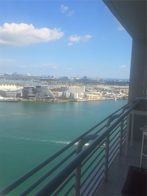 A high-rise balcony overlooks a bay with a city skyline and cruise ship terminal — 335 S BISCAYNE BOULEVARD UNIT 3400, MIAMI, FL