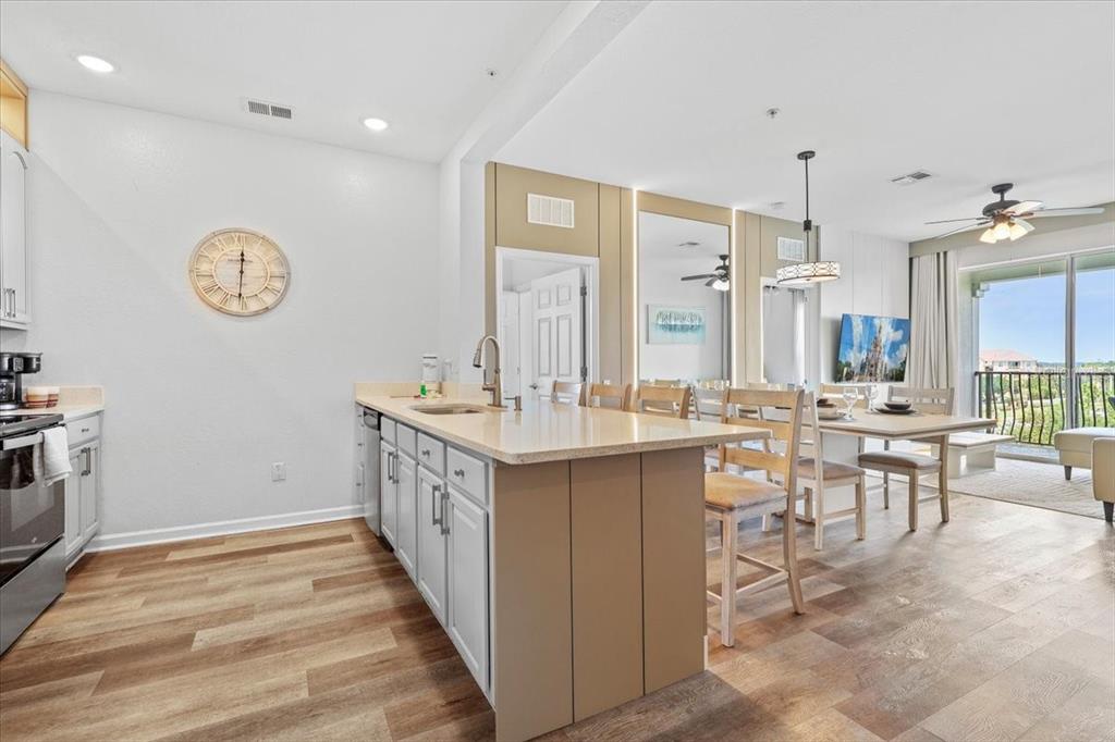 A kitchen with a central island and dining area opens to a balcony with views — 4126 BREAKVIEW DRIVE UNIT 40601, ORLANDO, FL