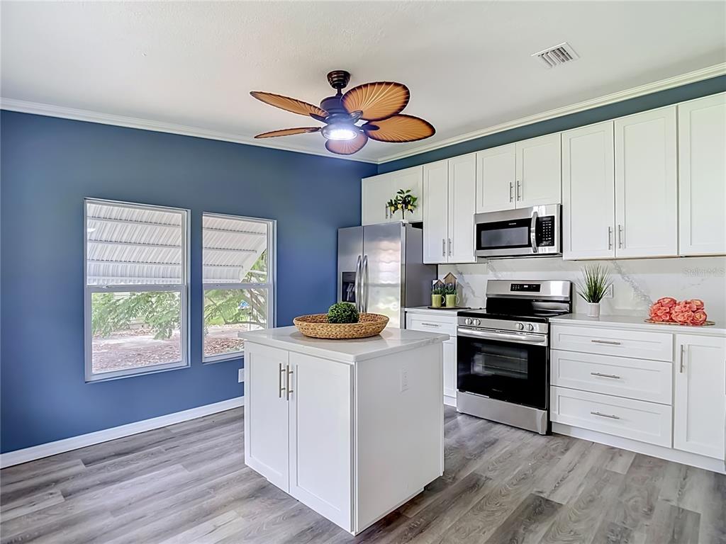 A single-story gray mobile home features a small front porch and white lattice skirting — 12331 PARKWOOD STREET, HUDSON, FL