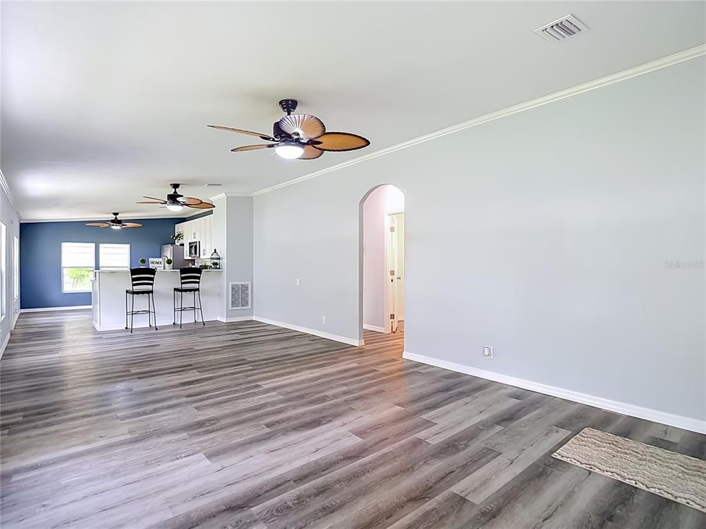 A white door with a diamond-shaped window sits on a porch with gray siding — 12331 PARKWOOD STREET, HUDSON, FL