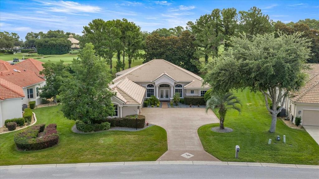 An aerial view shows a single-story house with a tiled roof and a concrete driveway — 1861 N EAGLE CHASE DRIVE, HERNANDO, FL