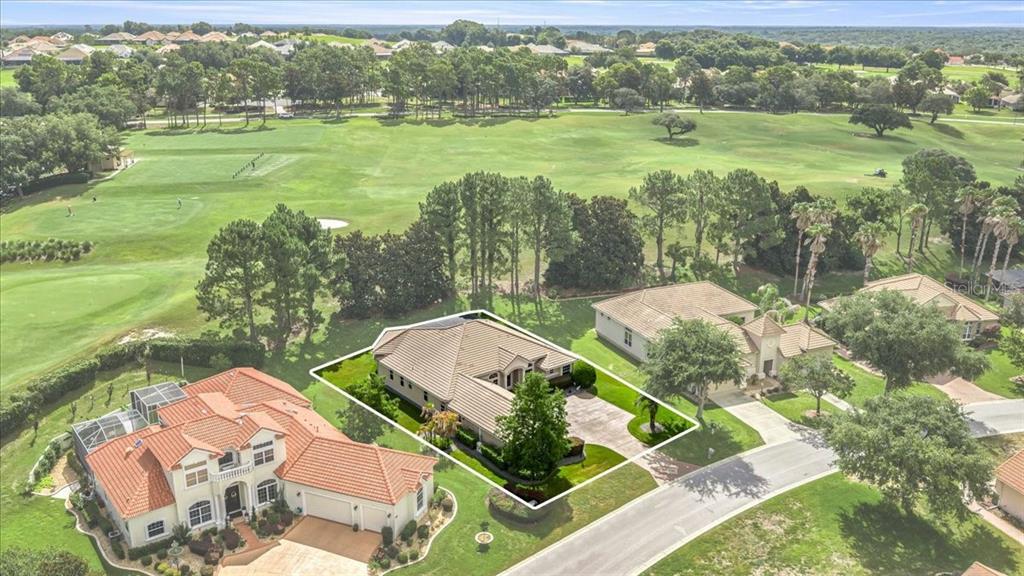 An aerial view shows a single-story house with a tiled roof bordering a golf course — 1861 N EAGLE CHASE DRIVE, HERNANDO, FL