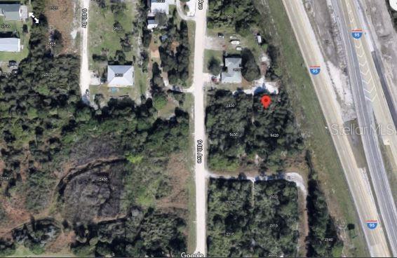 This aerial map view shows a vacant wooded lot located next to a highway — I-95, VERO BEACH, FL