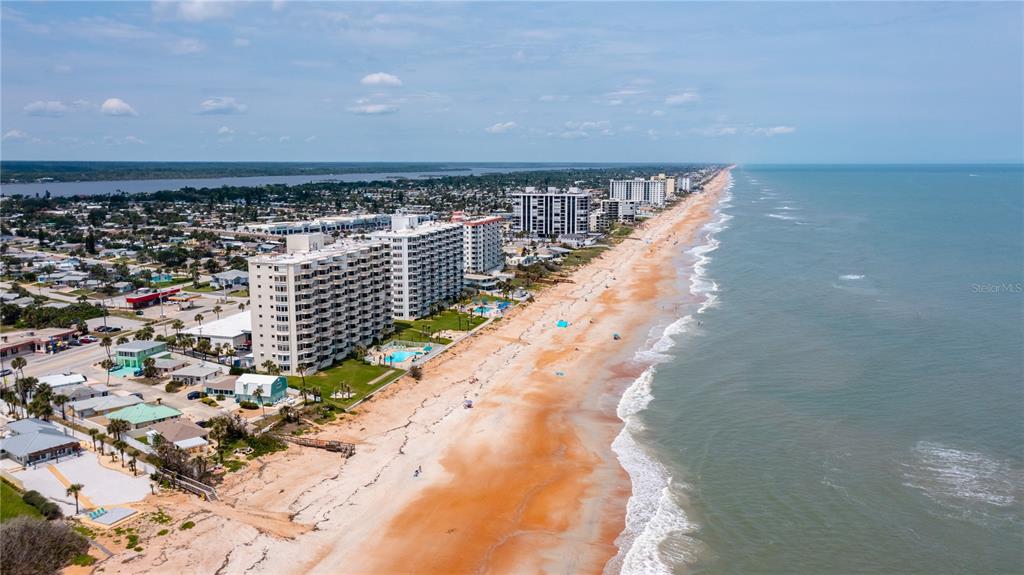 An aerial view of a sandy beach lined with high-rise condominiums and coastal homes — 1133 OCEAN SHORE BOULEVARD UNIT 302, ORMOND BEACH, FL