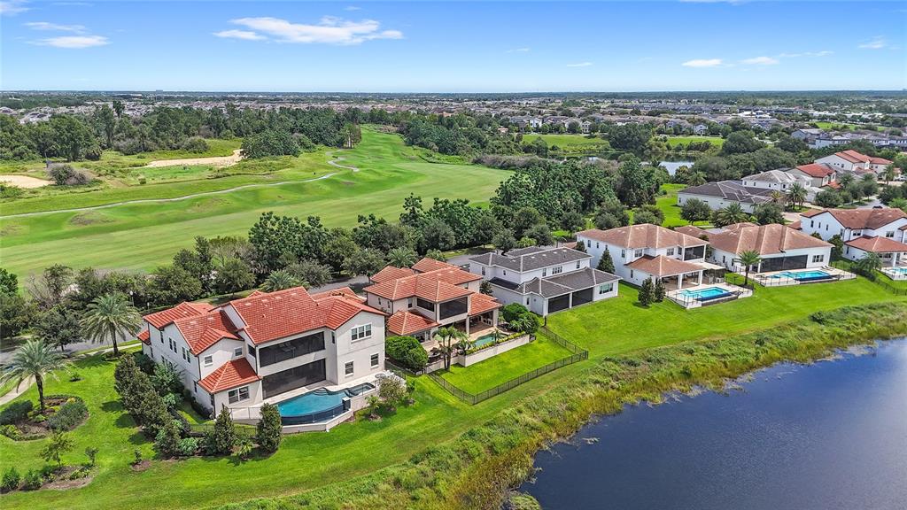 An aerial view shows several large houses with pools situated along a lake and golf course — 15475 SHOREBIRD LANE, WINTER GARDEN, FL