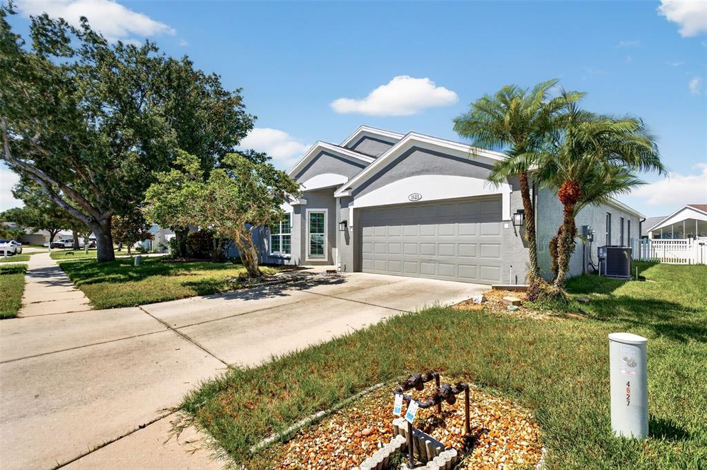 A single-story house with a gray garage, a concrete driveway, and a palm tree — 4623 SANIBEL WAY, BRADENTON, FL