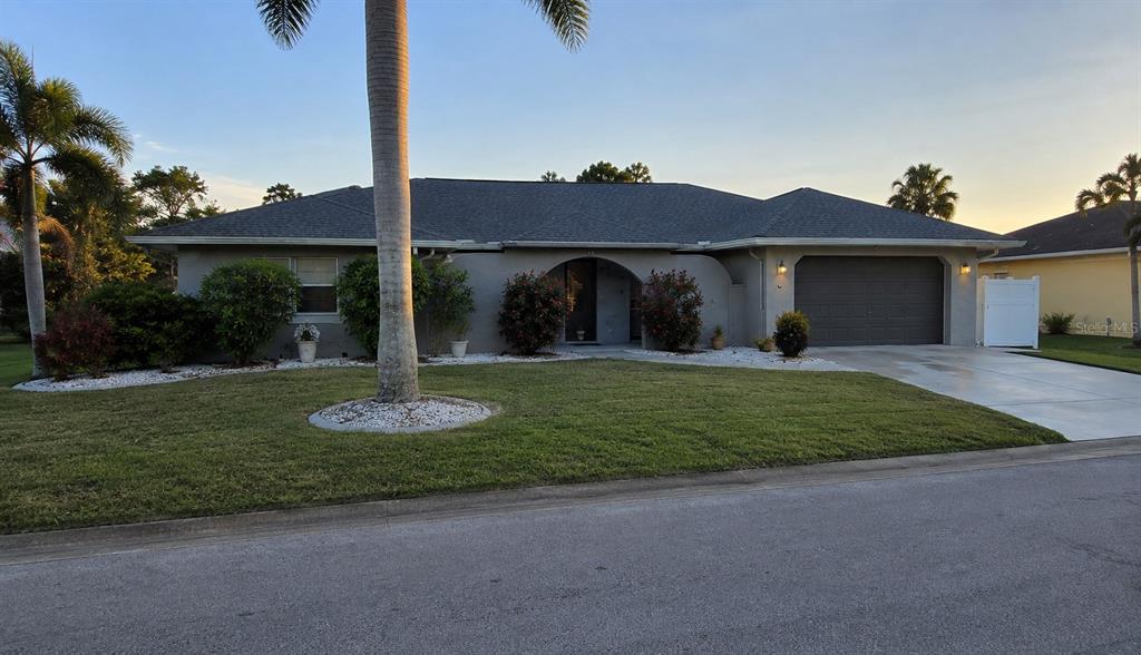 A single-story house with a gray roof, stucco exterior, and an attached two-car garage — 1840 FLAMETREE LANE, VENICE, FL