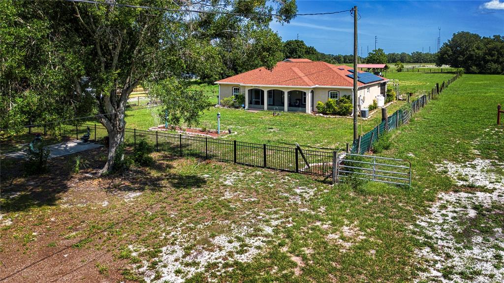 A single-story house with a red roof sits on a large, fenced grassy lot — 13522 COUNTY ROAD 672 HIGHWAY, RIVERVIEW, FL