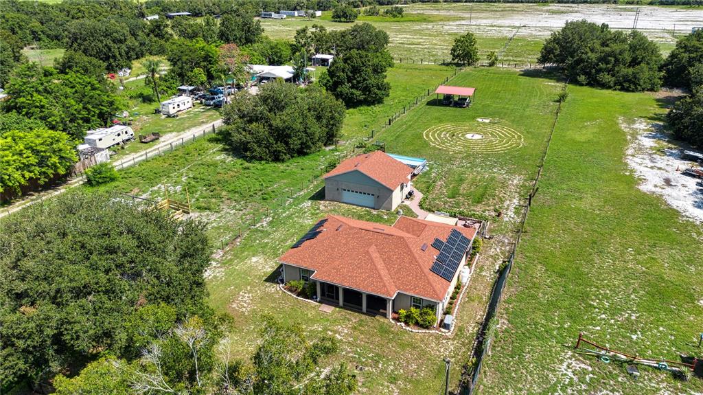 An aerial view shows a house with solar panels, a detached garage, and a lawn labyrinth — 13522 COUNTY ROAD 672 HIGHWAY, RIVERVIEW, FL
