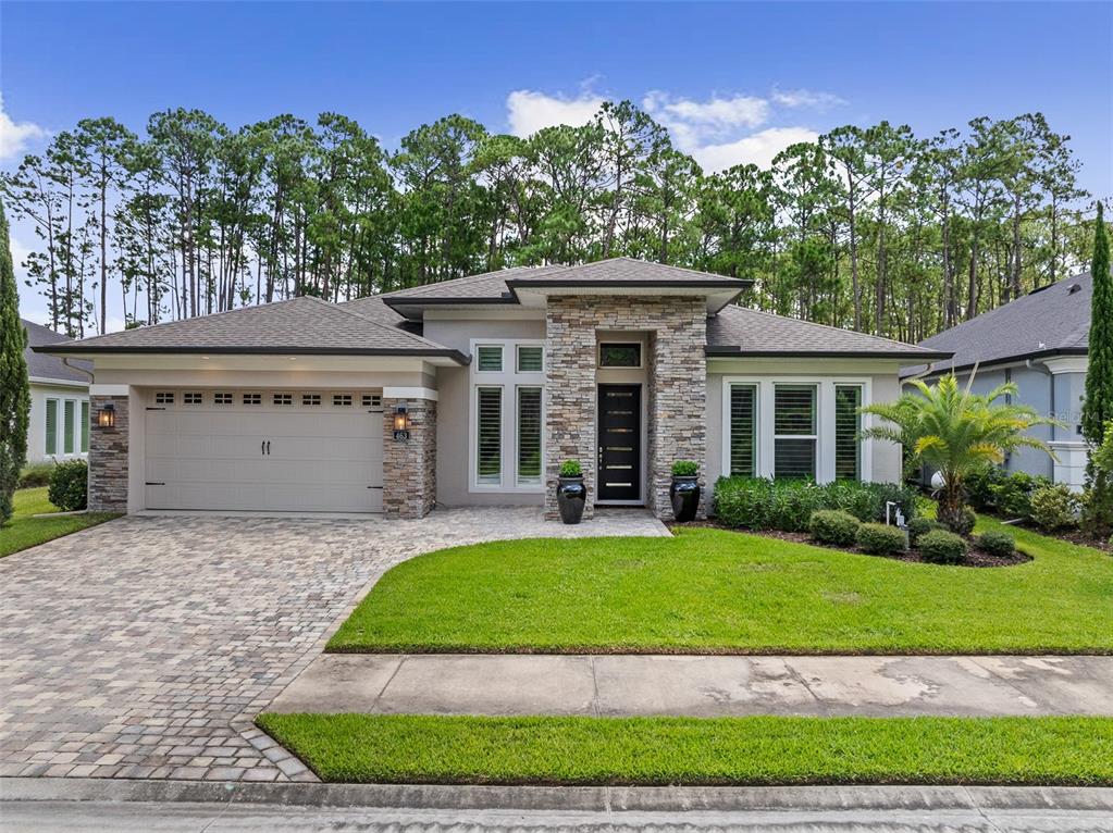 A single-story house with a stone facade, a paved driveway, and a manicured front lawn — 463 STIRLING BRIDGE DRIVE, ORMOND BEACH, FL