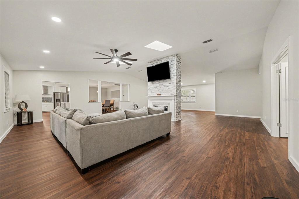 A kitchen with white cabinets, a blue island, stainless steel appliances, and an adjacent dining area — 1592 SKYLINE DRIVE, KISSIMMEE, FL
