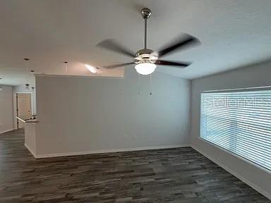 A living room features gray wood-look flooring, a ceiling fan, and a window with blinds — 15023 SE 93RD COURT, SUMMERFIELD, FL