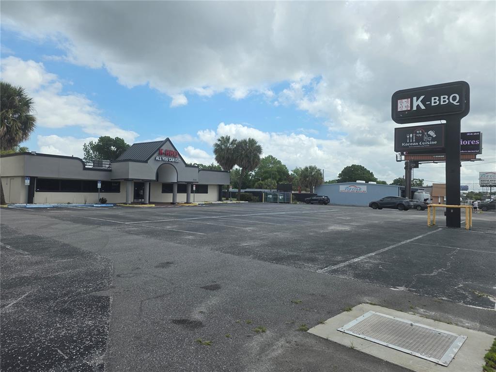 A restaurant building with a large parking lot and a prominent K-BBQ sign — 5101 E COLONIAL DRIVE, ORLANDO, FL
