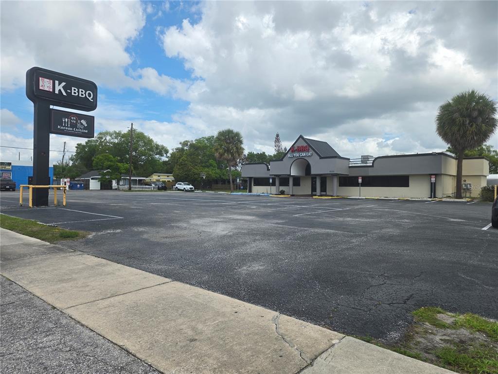 A commercial building with a large parking lot and a tall K-BBQ sign — 5101 E COLONIAL DRIVE, ORLANDO, FL