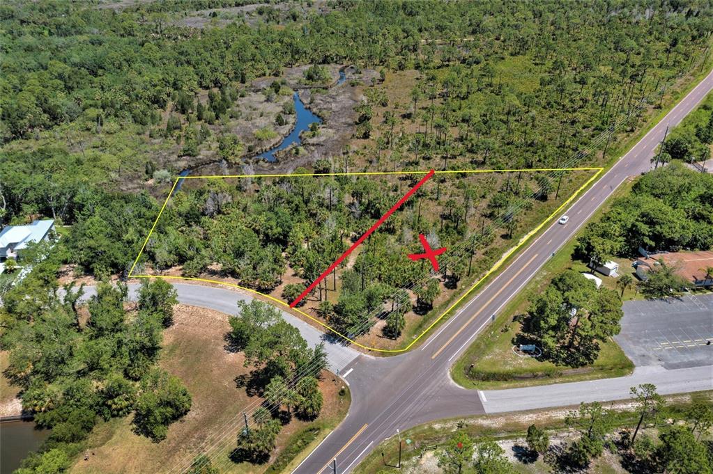 An aerial view shows a vacant, wooded lot outlined in yellow near a paved road — 00 GULF WAY, HUDSON, FL