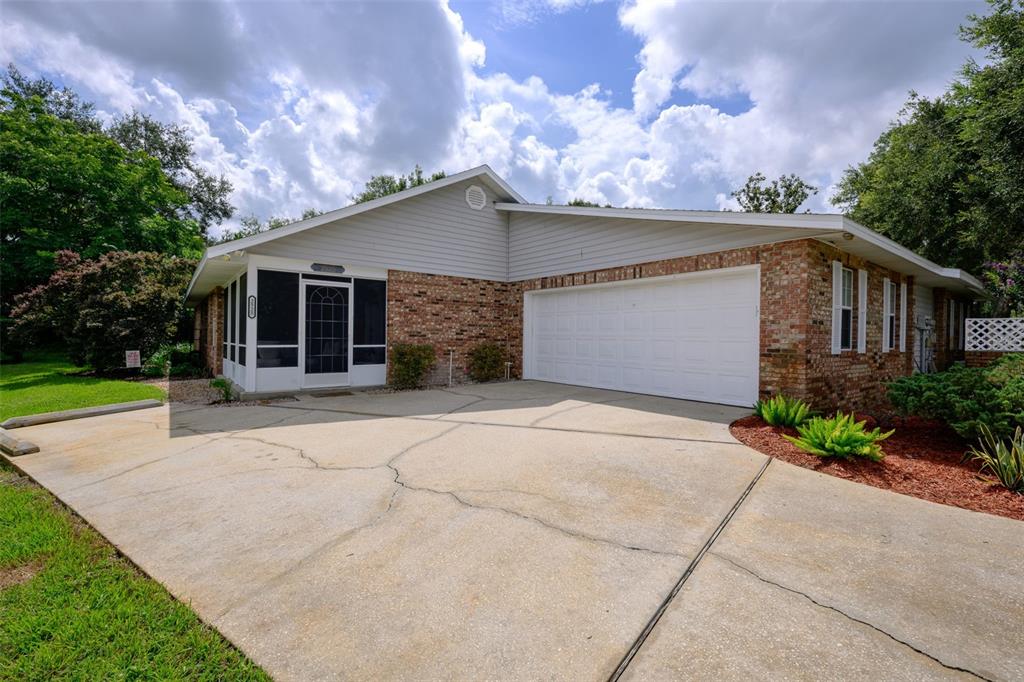 A single-story brick and siding house with a two-car garage and a screened front porch — 2525 S GLEN EAGLES DRIVE, DELAND, FL