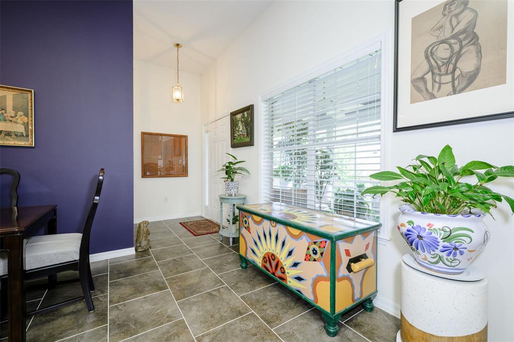 A room with a purple accent wall, tiled floor, decorative chest, and a potted plant — 2525 S GLEN EAGLES DRIVE, DELAND, FL