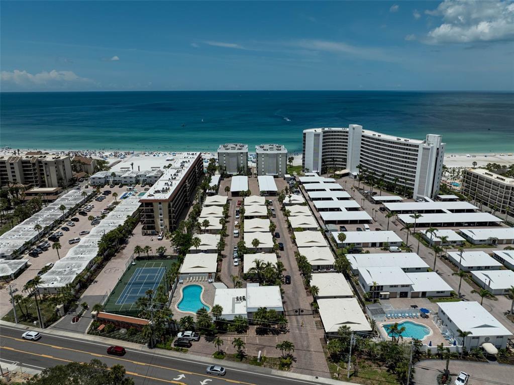 An aerial view shows a beachfront resort complex with multiple buildings, parking areas, and pools — 6308 MIDNIGHT PASS ROAD UNIT 6, SARASOTA, FL