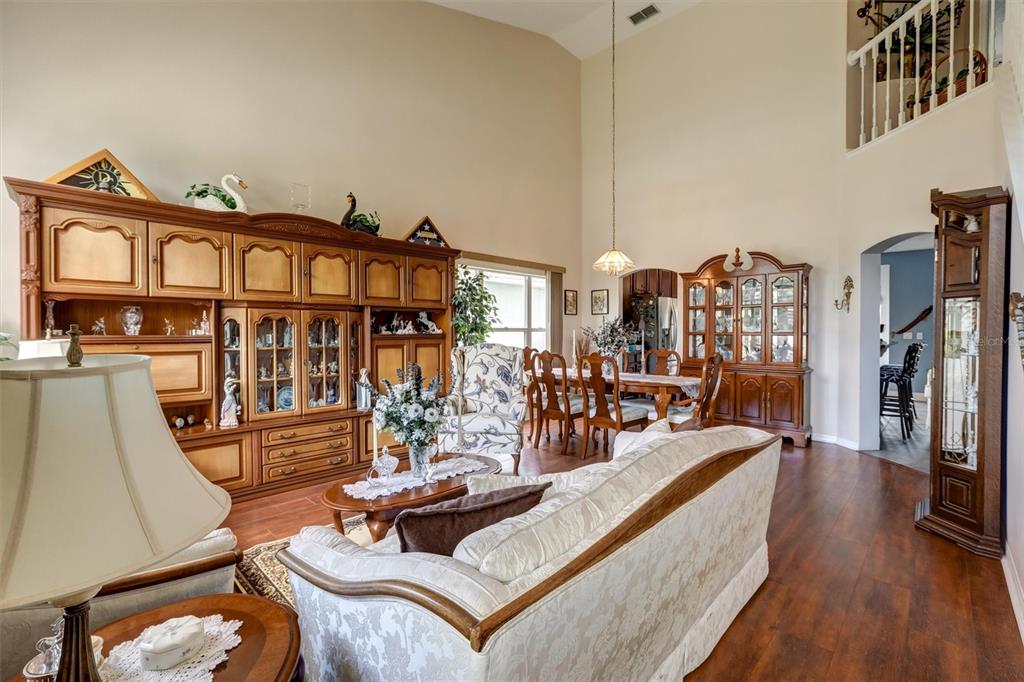 A living room with high ceilings, wood floors, and traditional wooden cabinetry and furniture — 1776 BOBTAIL DRIVE, MAITLAND, FL