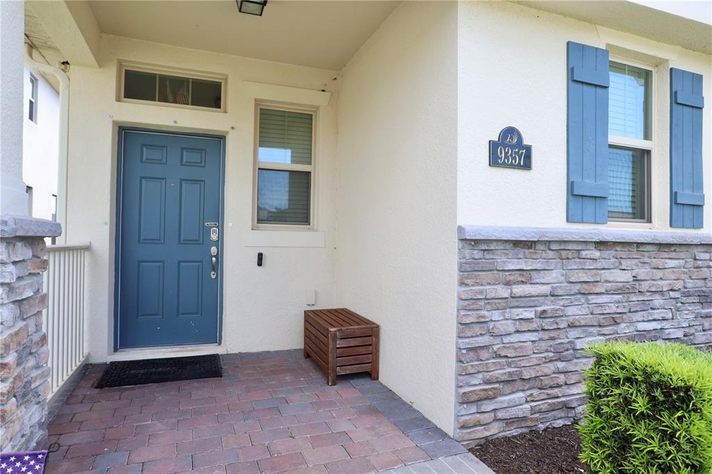 A front entryway features a blue door, stone veneer siding, and a brick paver porch — 9357 JAYWOOD ROAD, WINTER GARDEN, FL