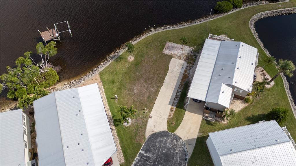 An aerial view shows a waterfront lot with a driveway between two mobile homes — 4300 RIVERSIDE DRIVE UNIT 114, PUNTA GORDA, FL