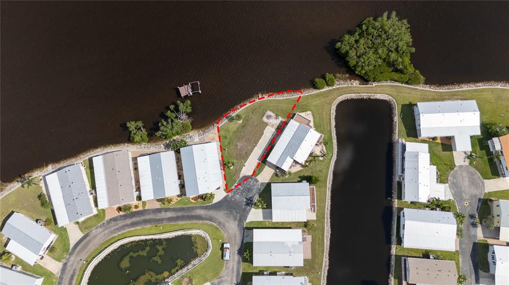 This aerial view shows a waterfront mobile home with a red-outlined lot boundary — 4300 RIVERSIDE DRIVE UNIT 114, PUNTA GORDA, FL