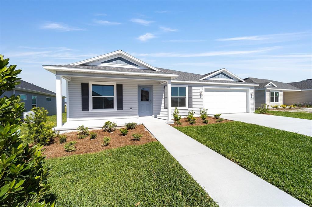 A single-story house with light gray siding, a white garage door, and a concrete walkway — 2421 HOBKIRK LOOP, MIDDLETON, FL