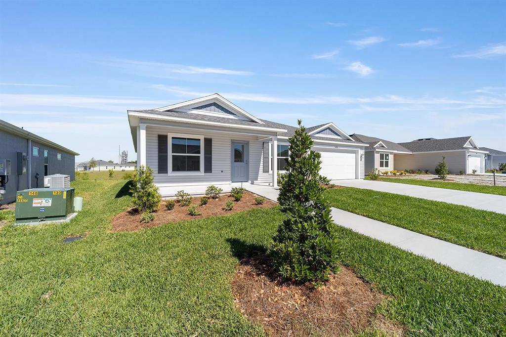 A light-colored, single-story suburban house with a garage and a manicured front lawn — 2421 HOBKIRK LOOP, MIDDLETON, FL