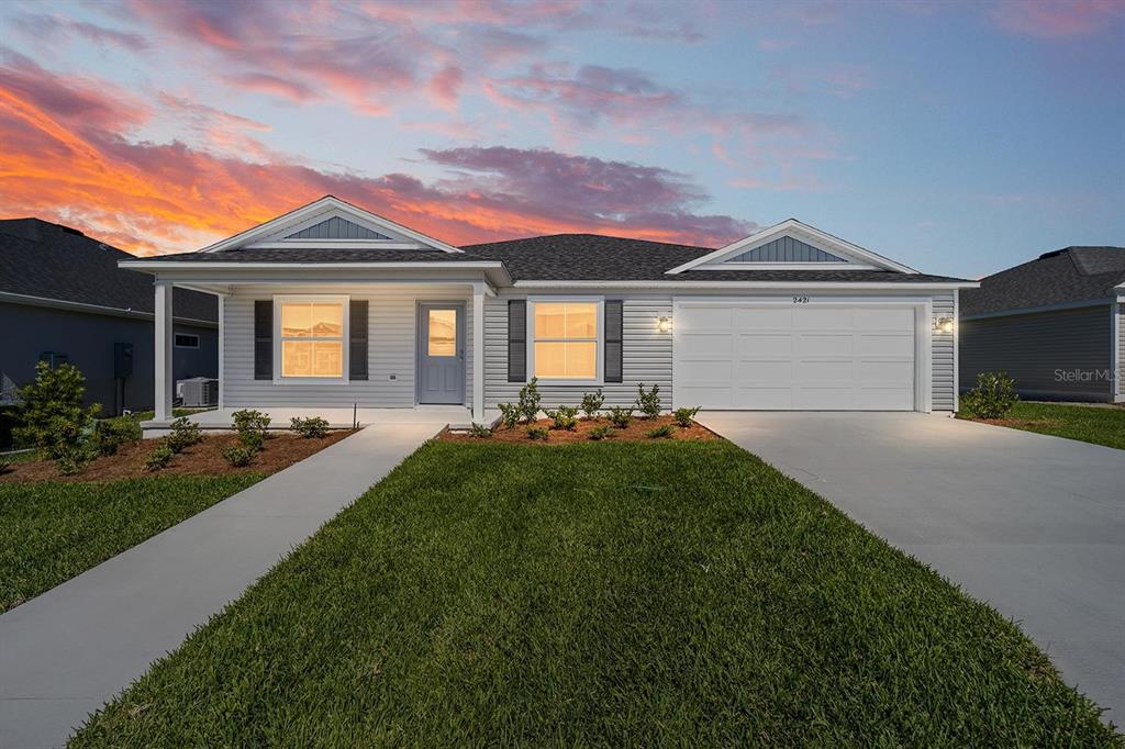 A single-story house with light gray siding, a two-car garage, and a front porch — 2421 HOBKIRK LOOP, MIDDLETON, FL