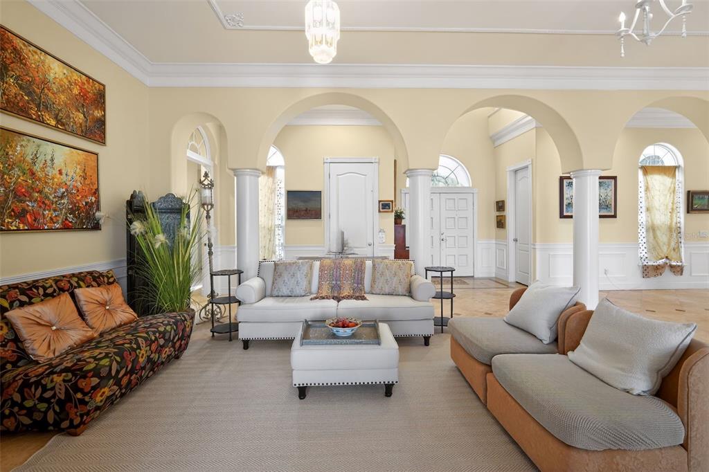 A living room features arched openings, white columns, a neutral rug, and varied seating furniture — 1444 HARBOR DRIVE, SARASOTA, FL