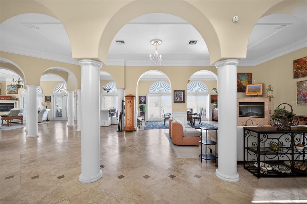 A spacious living area features arched entryways, white columns, and light-colored tile flooring — 1444 HARBOR DRIVE, SARASOTA, FL