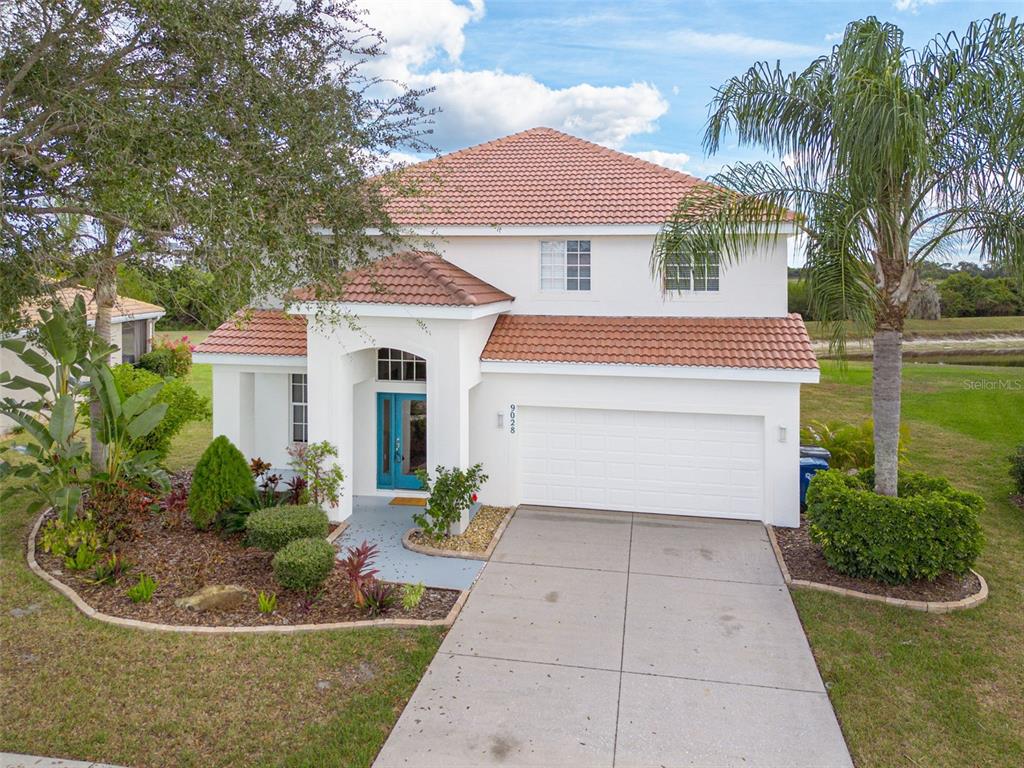 A two-story white stucco house with a red tile roof and a two-car garage — 9028 WILLOWBROOK CIRCLE, BRADENTON, FL