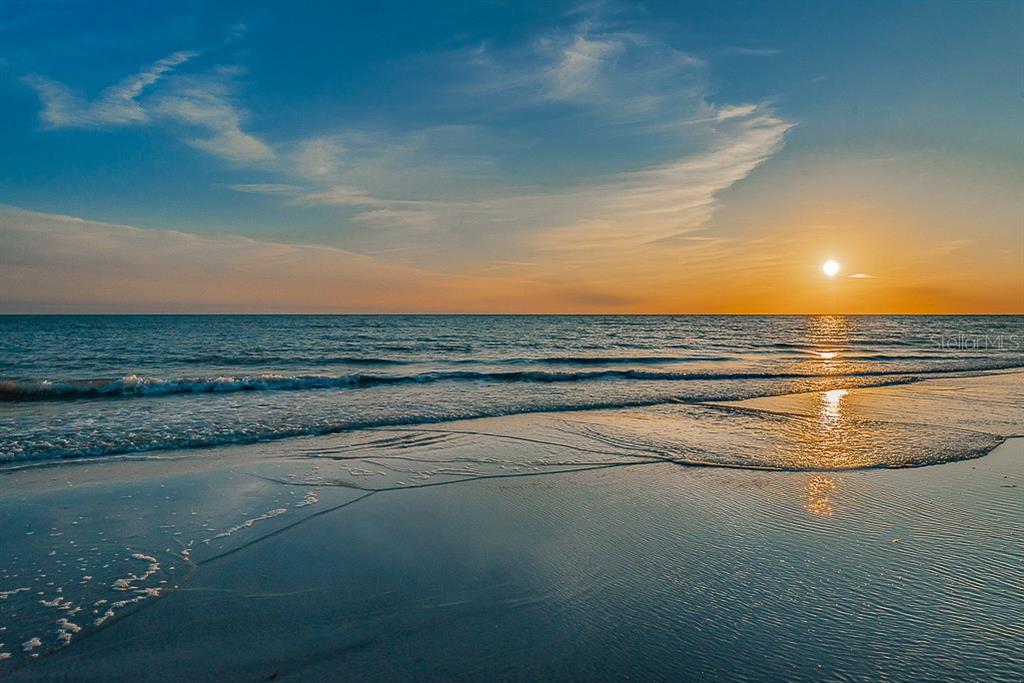 A sunset view over the ocean with waves gently washing onto a sandy beach — 3500 E MARITANA DRIVE UNIT 3, ST PETE BEACH, FL