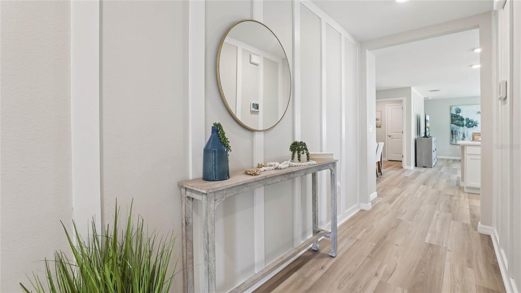 A hallway features light wood flooring, board and batten walls, and a console table — 2146 NE 33RD LANE, OCALA, FL