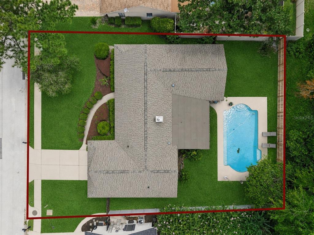 An aerial view shows a house with a shingled roof, pool, and surrounding lawn — 734 RIVERBEND BOULEVARD, LONGWOOD, FL