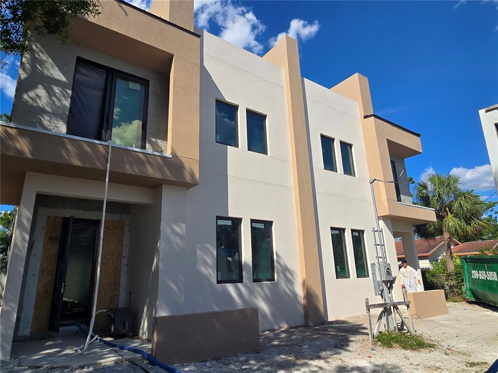 A two-story modern townhouse under construction with a tan and white stucco exterior — 1755 8TH STREET UNIT West, SARASOTA, FL