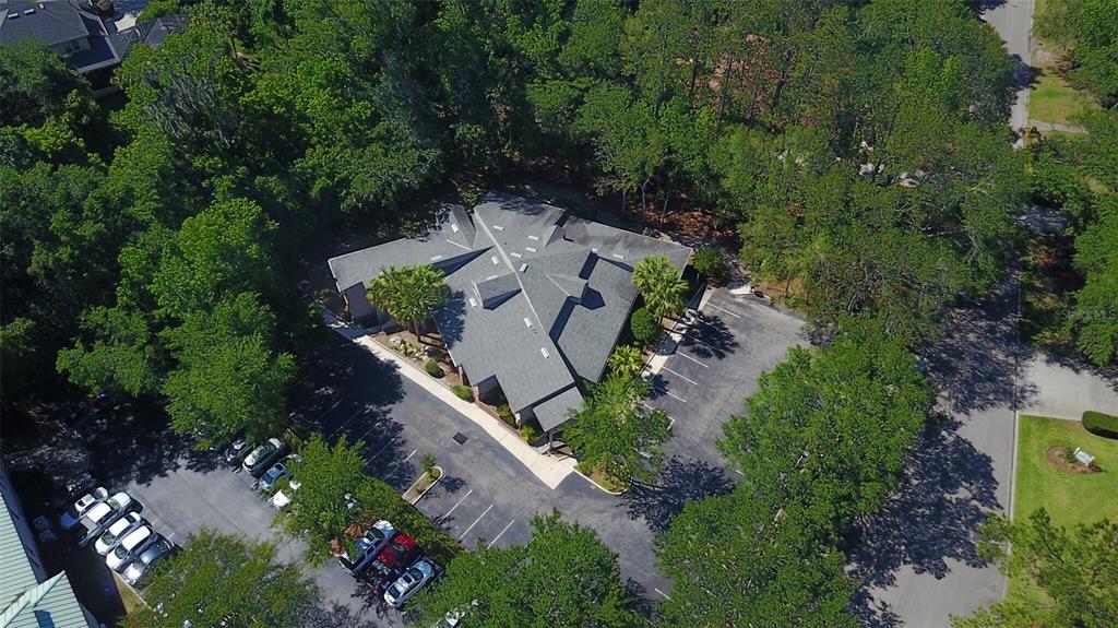 An aerial view shows a commercial building surrounded by trees with two parking lots — 1034 NW 57TH STREET, GAINESVILLE, FL