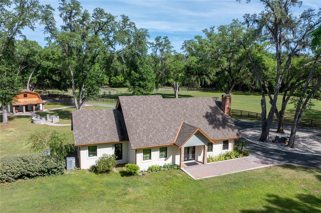 An aerial view of a house with a brown shingled roof and a detached barn — 10925 SW 16TH AVENUE, OCALA, FL