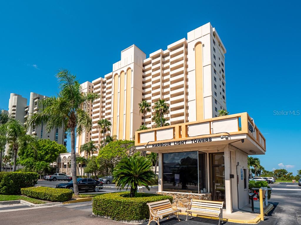 A multi-story residential building stands behind a gated entrance booth with a security guard station — 1270 GULF BOULEVARD UNIT 603, CLEARWATER, FL