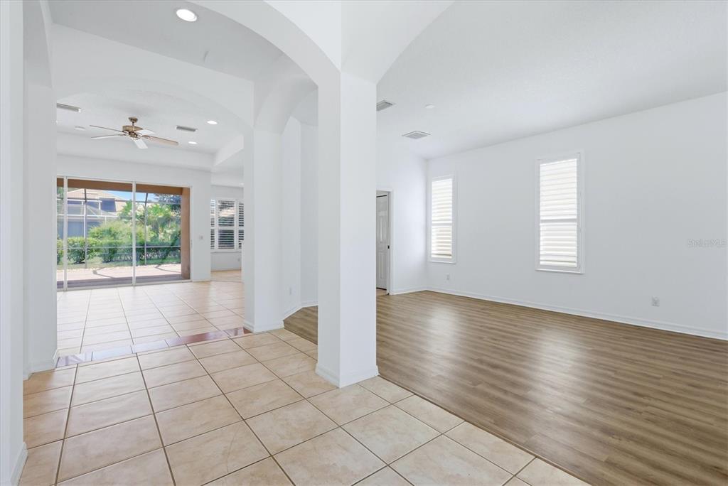 An interior view showing a tiled entryway transitioning into a living area with wood flooring — 9089 WILLOW BROOK DRIVE, SARASOTA, FL